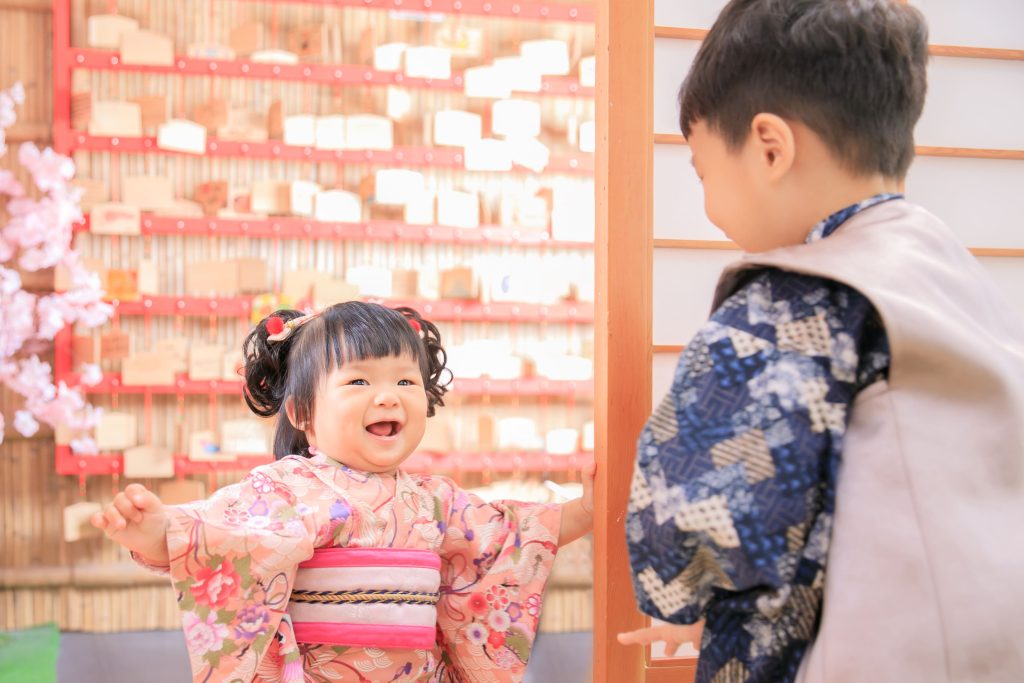 寶寶抓周拍攝花絮，穿著和服的兄妹互動畫面，妹妹開心對著哥哥微笑，呈現自然又溫馨的親子時光